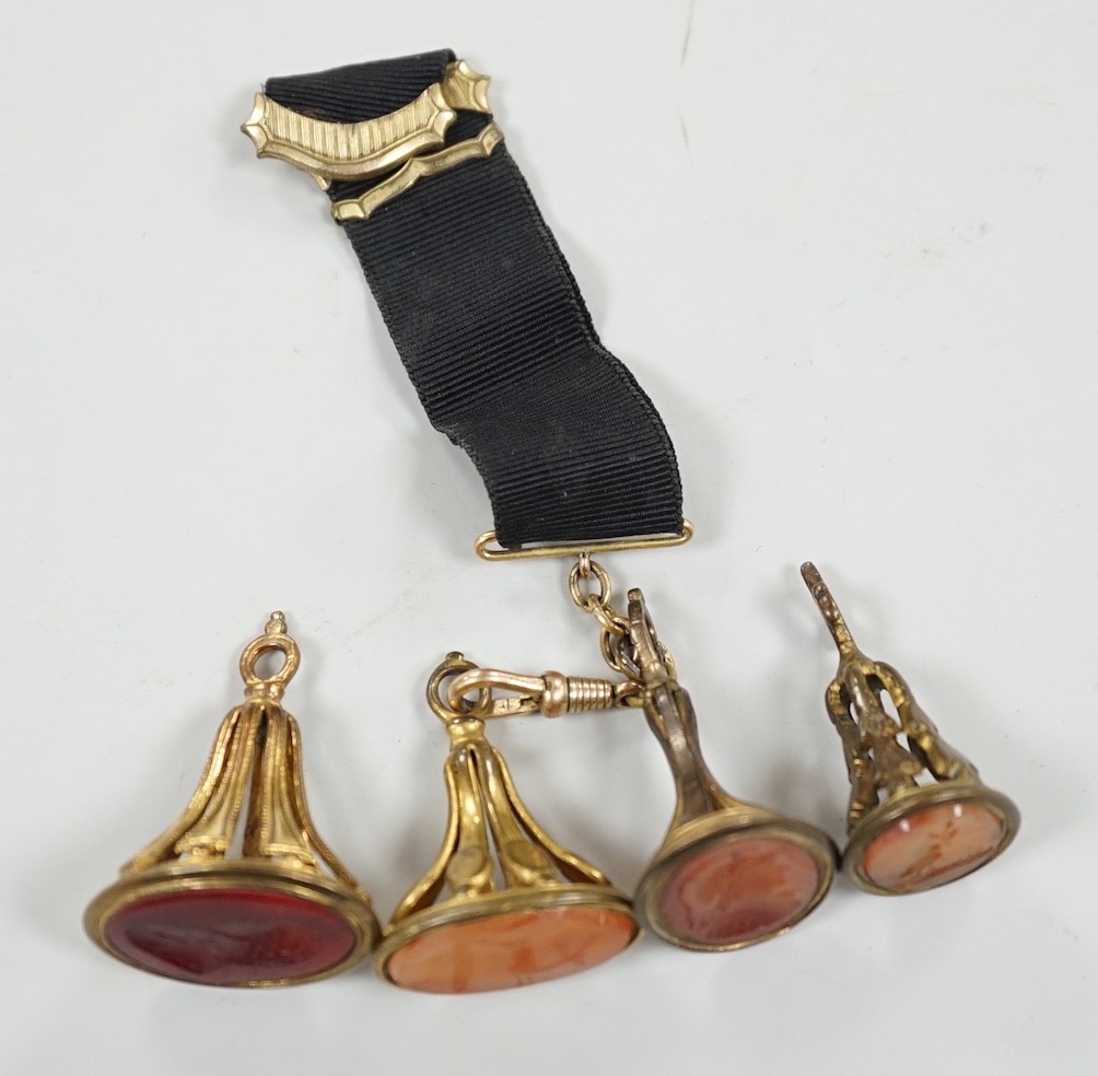 Four assorted 19th century gold plated and agate or hardstone set oval fob seals, largest 37mm, two matrices carved with busts and two with animals.